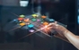 A hand is holding a tablet with a lot of icons on it.